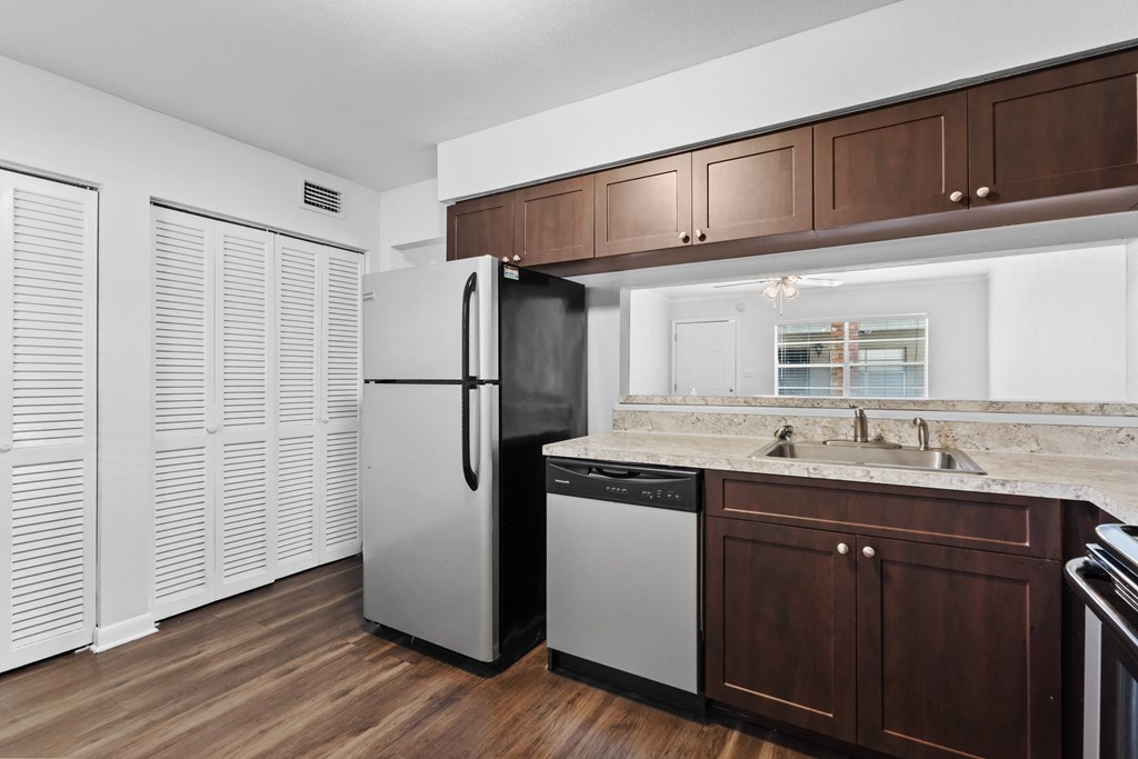 a kitchen with dark wood cabinets and white appliances