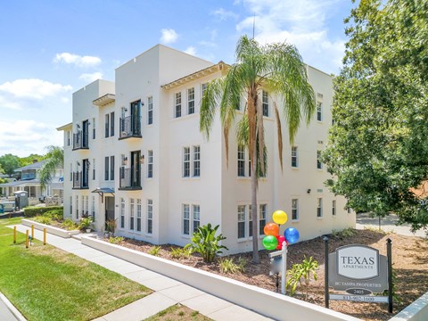 a white building with palm trees in front of it