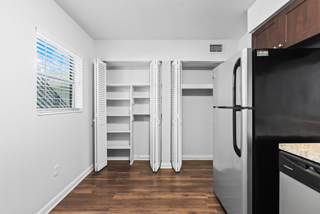 a small kitchen with white walls and wood flooring
