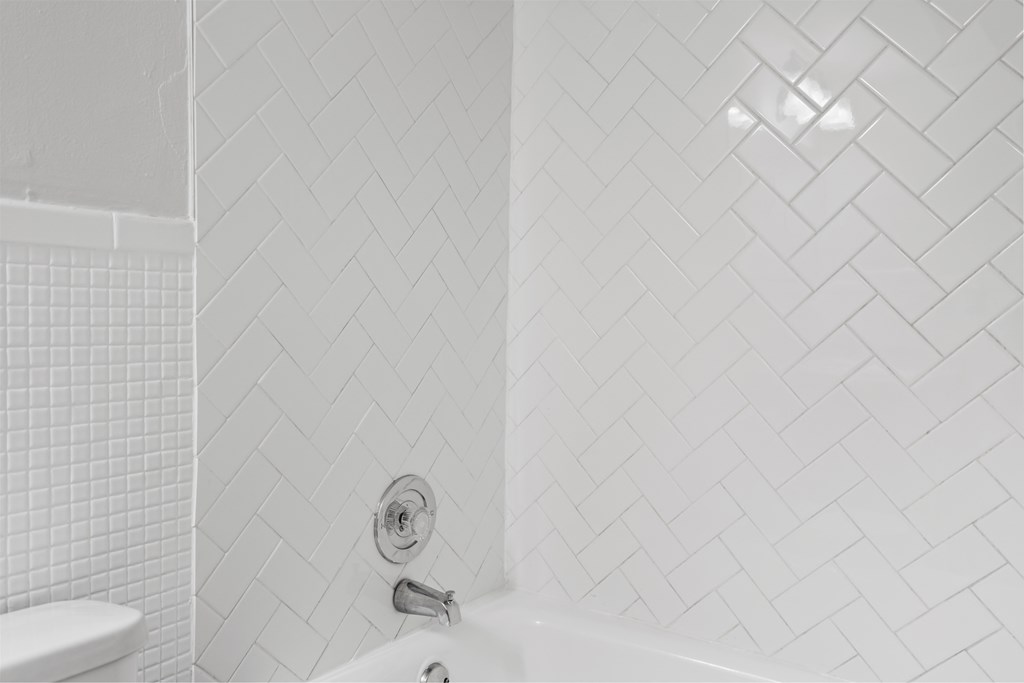 a bathroom with a white tub and a white toilet