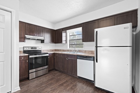 an image of a kitchen with white appliances and wooden cabinets