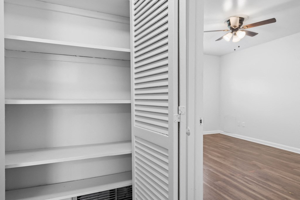 a bedroom with a closet and a ceiling fan