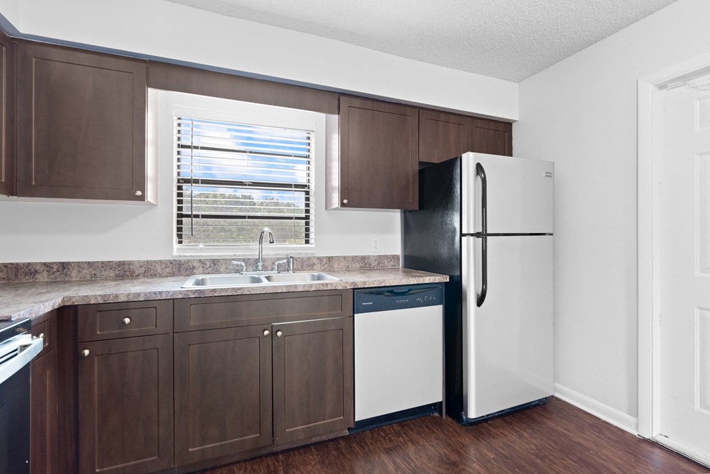 a kitchen with brown cabinets and a white dishwasher