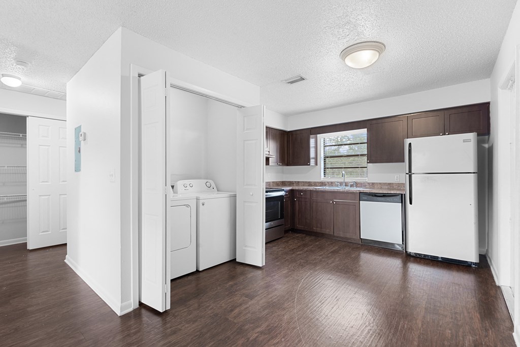 a kitchen with white appliances and brown cabinets