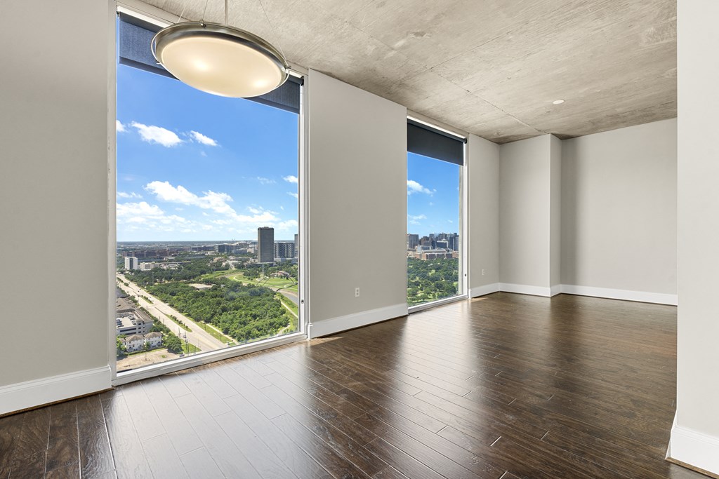 Empty living room with panoramic city views through large windows in Houston, TX