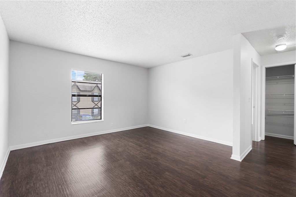 a bedroom with hardwood flooring and white walls