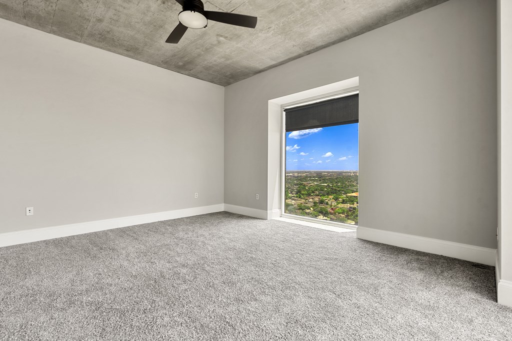 Empty room with expansive city skyline visible through a large window in Houston, TX