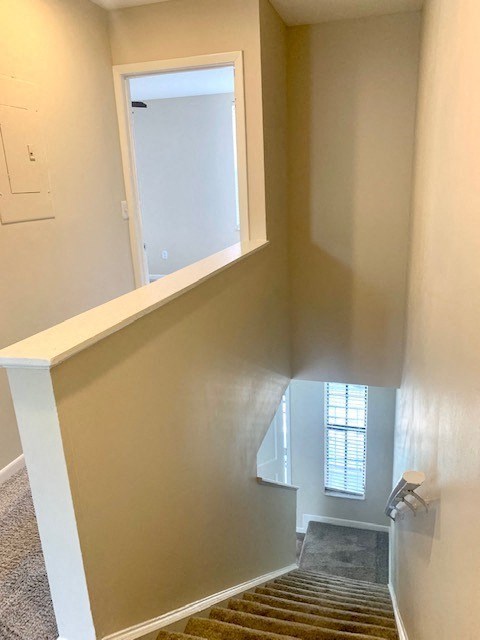 a hallway with a staircase and a window