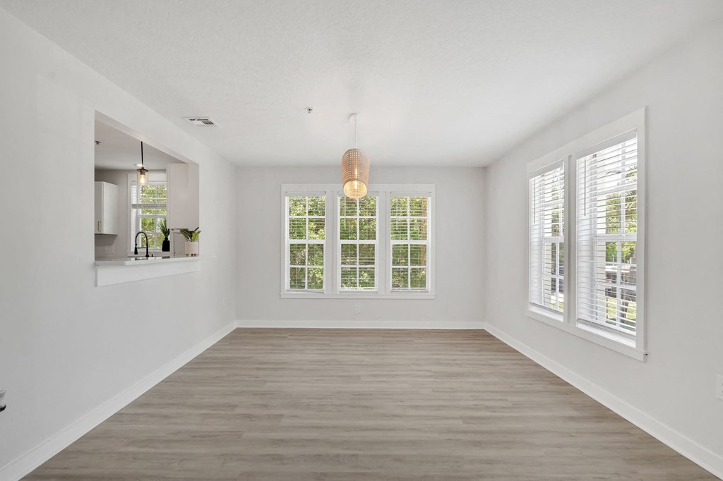 a living room with white walls and a large window