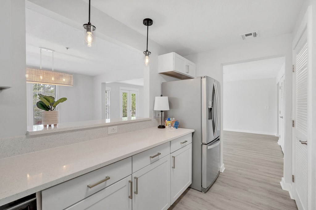 a kitchen with white cabinets and a stainless steel refrigerator
