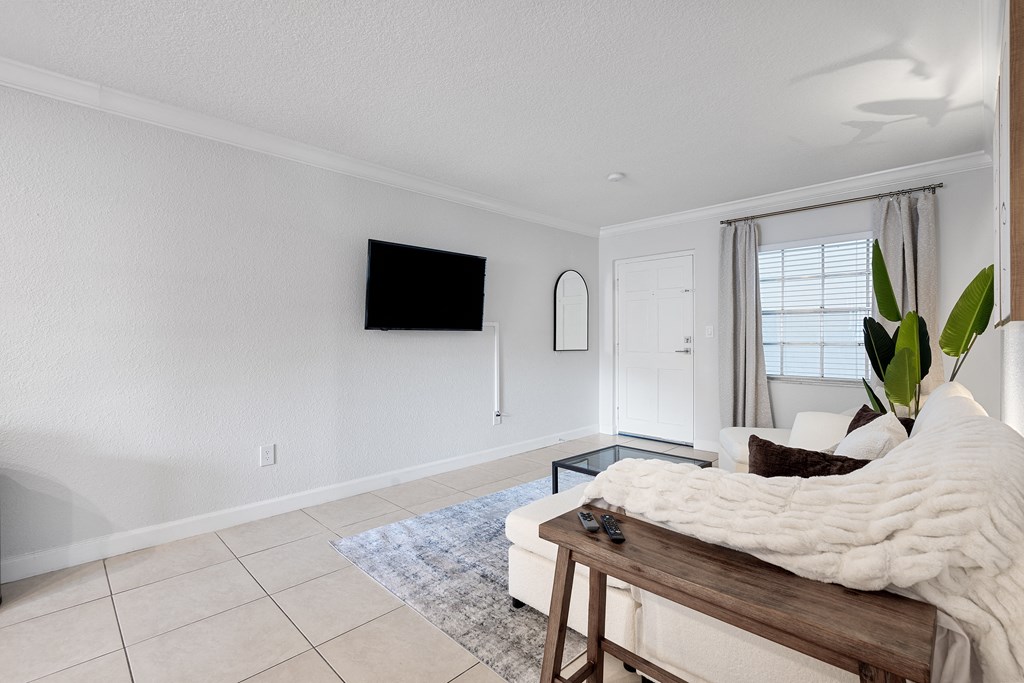 a living room with a couch and a tv on the wall