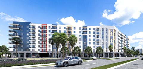 A modern multi-story building with a parking lot in front.
