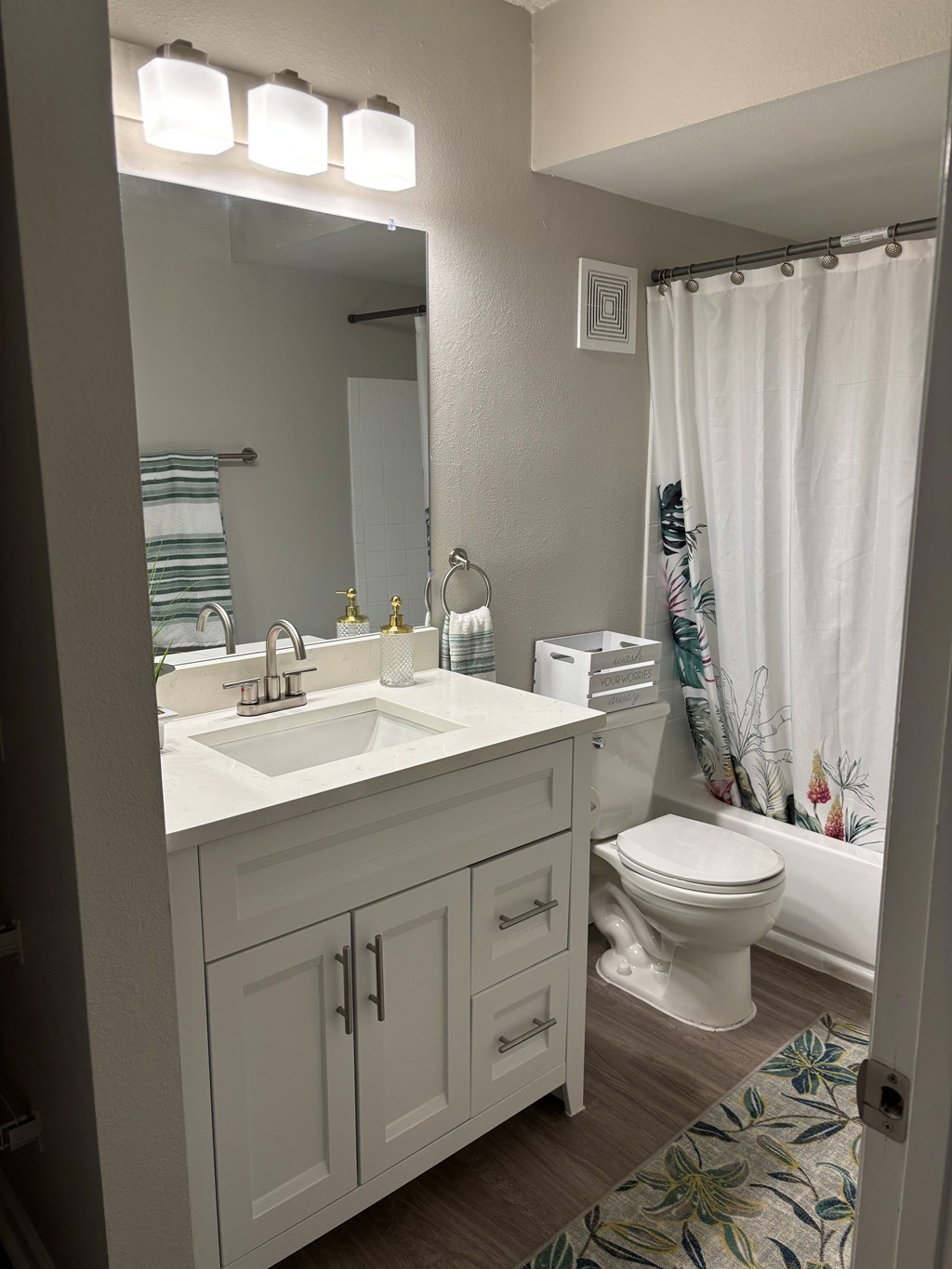 A white bathroom with a sink, toilet, and shower.