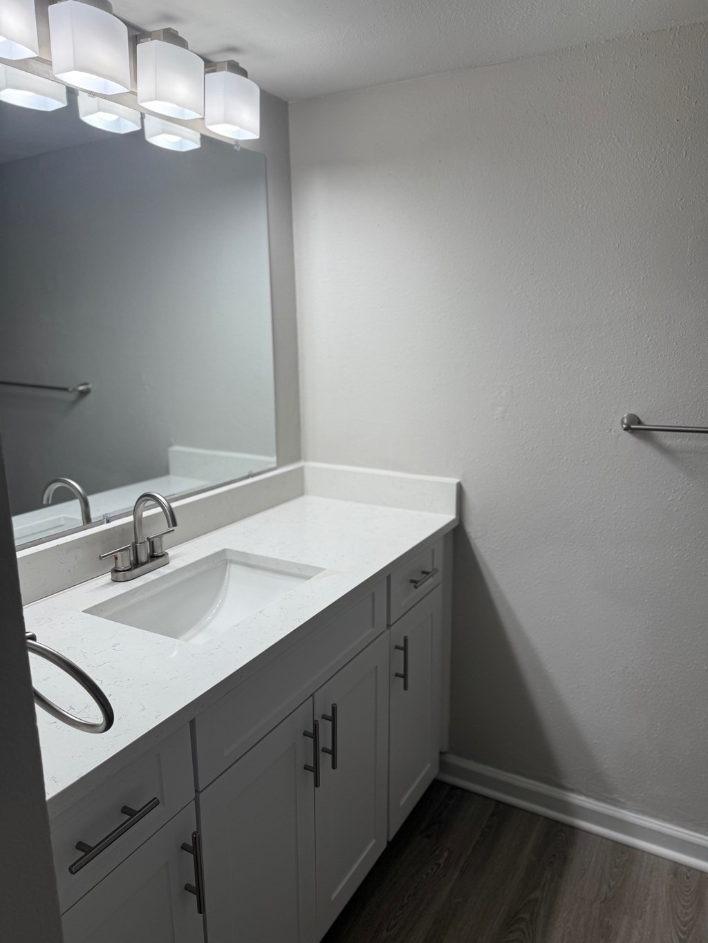 A bathroom with a white counter top and a round sink.