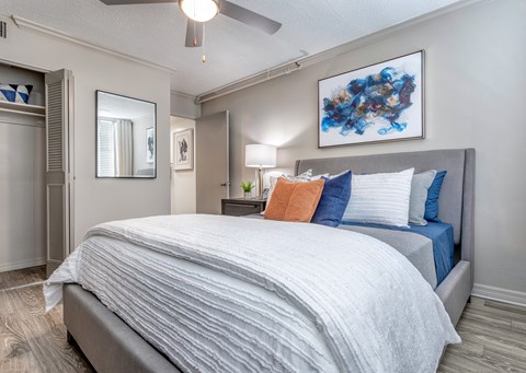 A bedroom with a large bed and a painting on the wall.