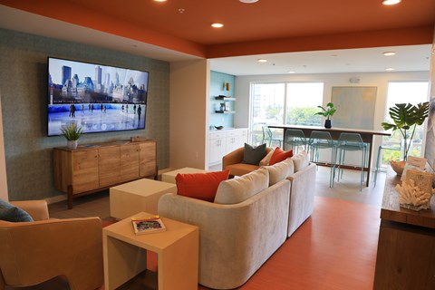 A living room with a television, couch, and chairs.