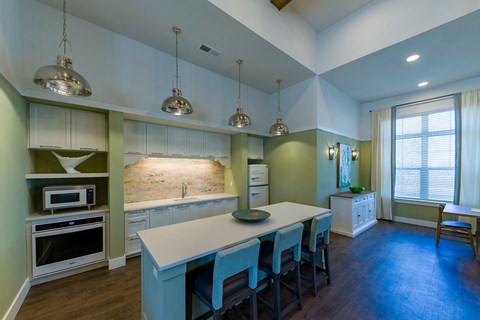 a kitchen with a large island and blue chairs