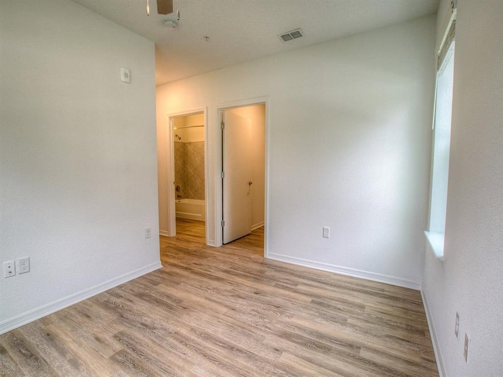 the living room and bedroom of an empty house with wood flooring