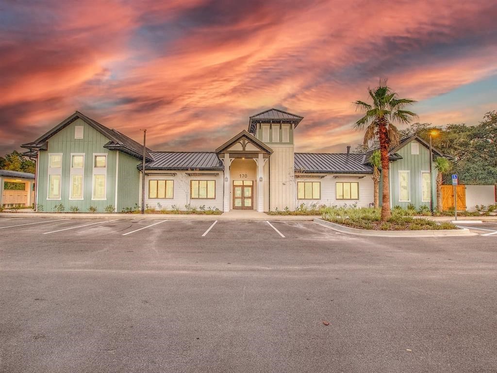 a building with a parking lot and a cloudy sky
