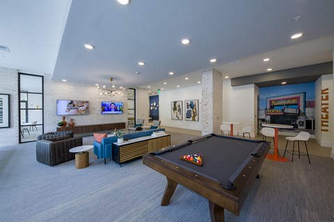 a community room with a pool table and a tv