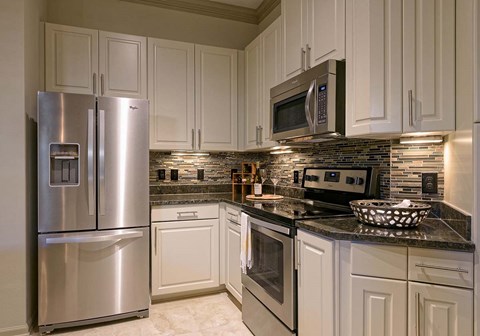 a kitchen with stainless steel appliances and white cabinets