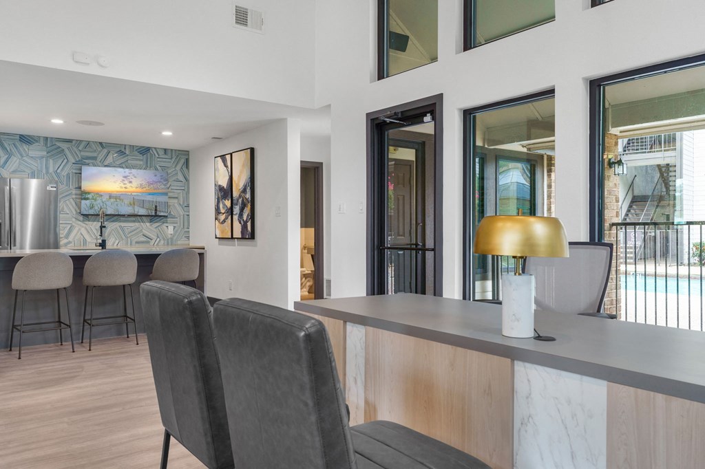 a living room with a bar and a kitchen in the background