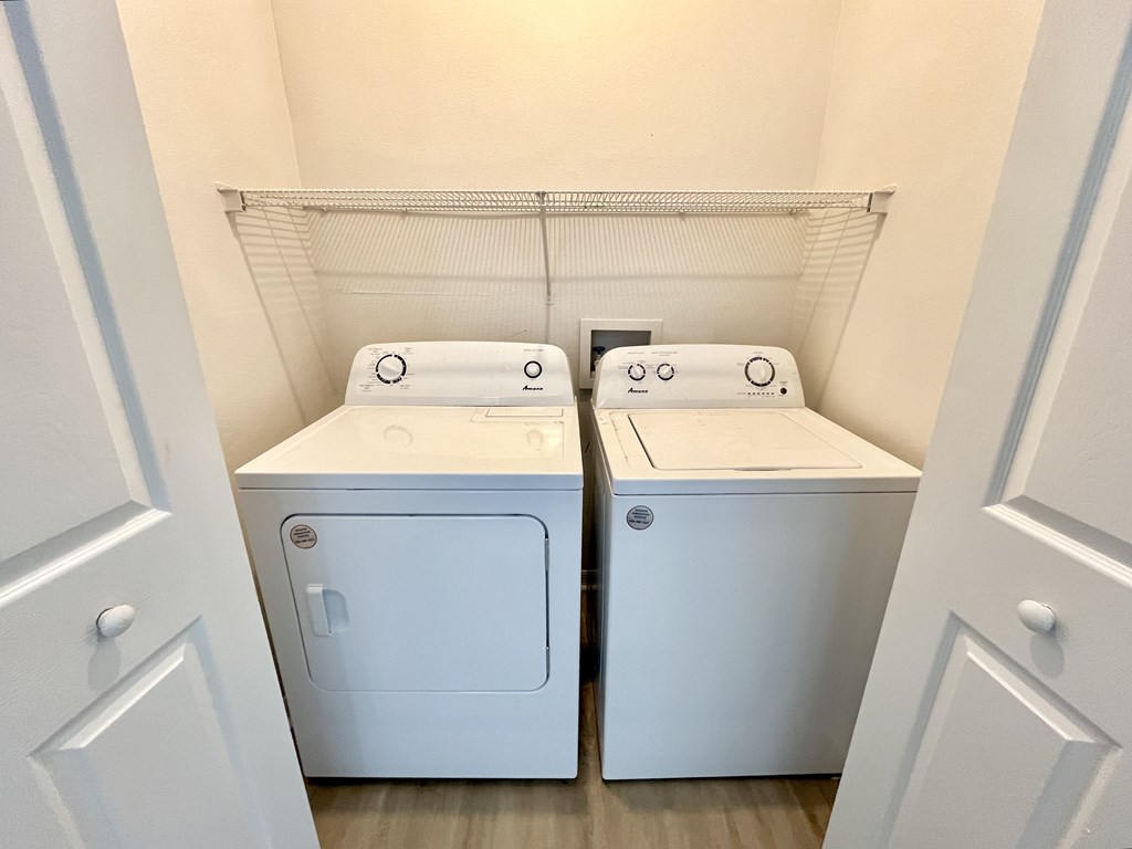 Two white front loading washing machines in a laundry room.