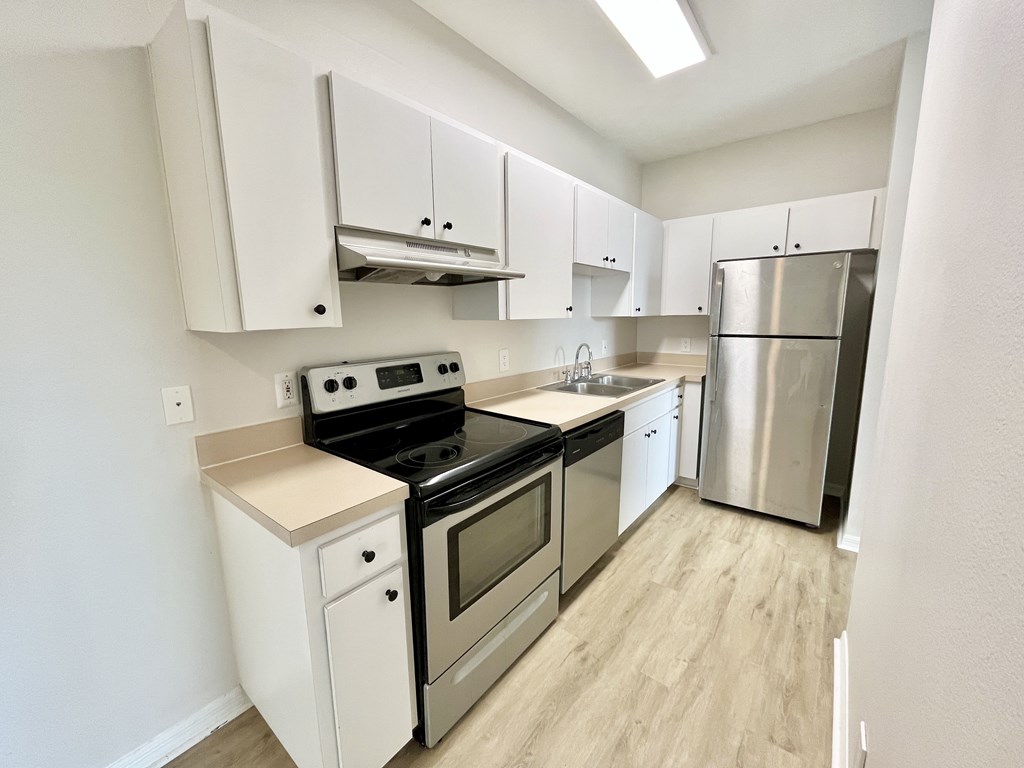 A kitchen with white cabinets and stainless steel appliances.
