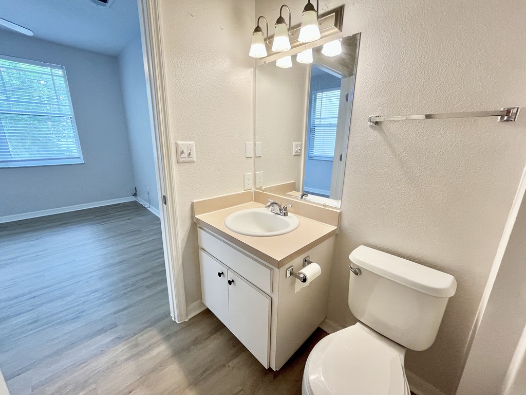 A white toilet sits next to a sink in a bathroom.