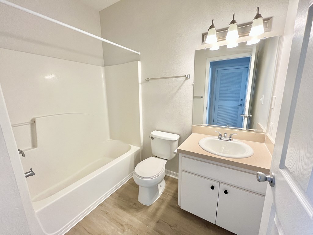 A white bathroom with a blue door.