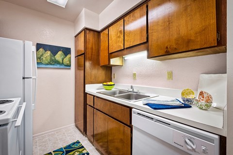 our apartments have a modern kitchen with white appliances and wood cabinets