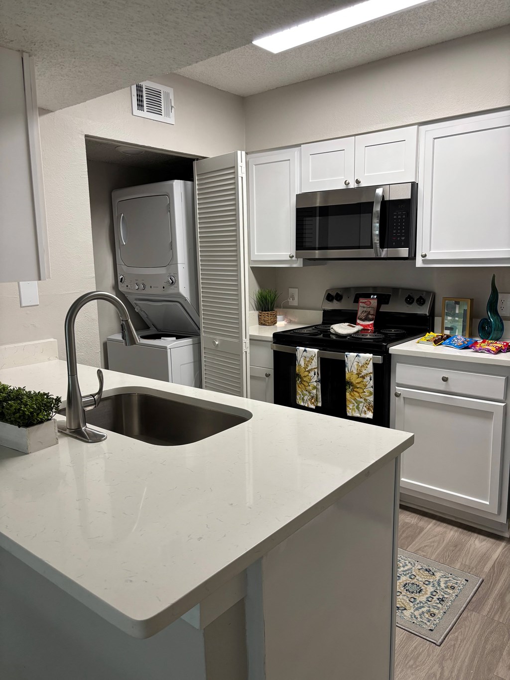 A kitchen with a sink and a microwave above it.