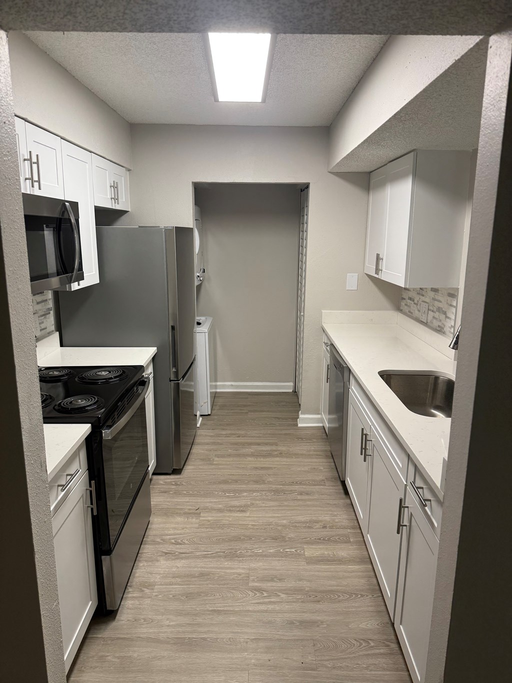 A kitchen with white cabinets and a black stove top oven.
