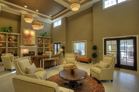 A living room with a brown coffee table and beige chairs.