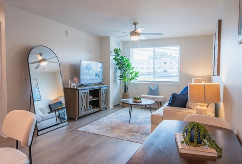 A living room with a white sofa, a wooden coffee table, and a large mirror.