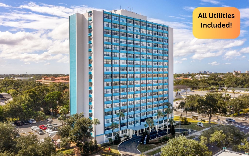 A tall building with a sign that says "All Utilities Included!"