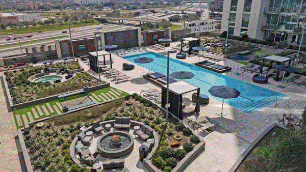 Aerial view of the pool courtyard surrounded by greenery and lounge areas in Houston, TX.