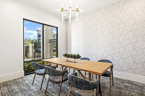 Modern dining room with wood table and blue chairs at Longleaf at St. Johns Apartments, St. Johns, FL 32259