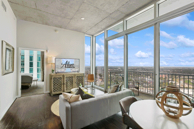 Spacious living room with floor-to-ceiling windows offering panoramic city views at Med Center.