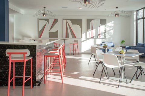 A modern dining area with red chairs and a white table.