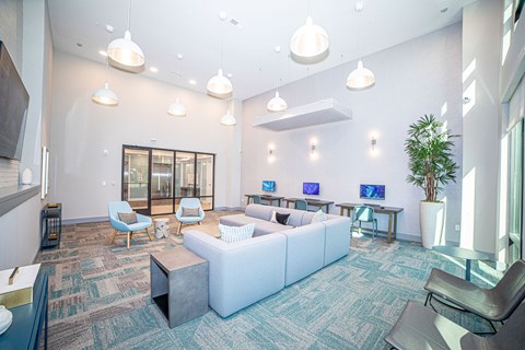 A modern office space with a white sofa set, a grey coffee table, and a green plant.