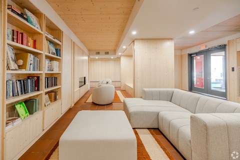 A living room with a white couch and a bookshelf filled with books.