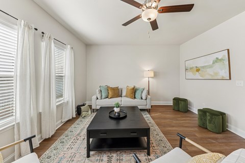 A living room with a black coffee table and white couches.