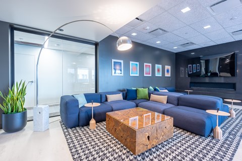 A modern living room with a blue couch and a wooden coffee table.