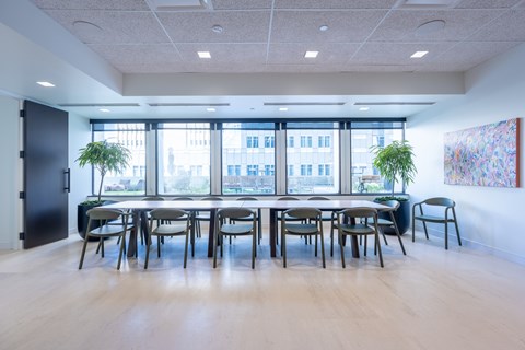 A conference room with a long table and chairs.