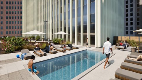 A man is walking towards a pool with people sitting around it.