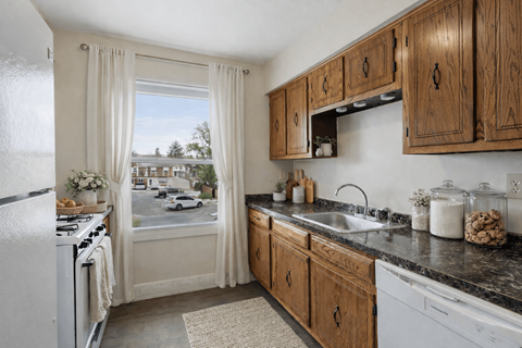 A kitchen with wooden cabinets and a white fridge.