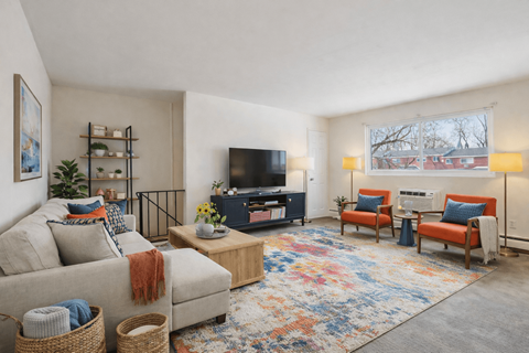 A living room with a couch, a chair, a coffee table, and a television.