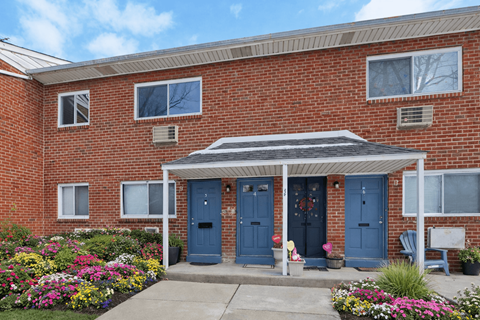 A red brick house with a blue door and a small porch.