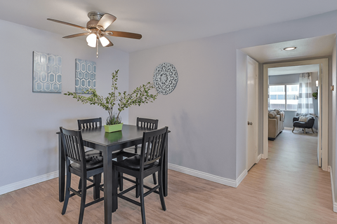 A dining room with a table and chairs.